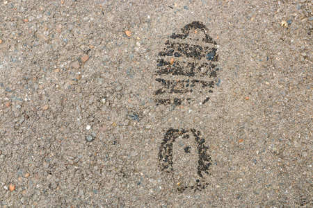 Wet footprint on asphalt surface. warning - thief.