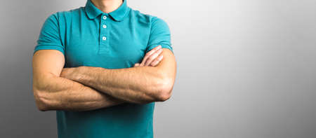confidence and reliability. closeup crossed arms of a man on grey background with copy spaceの写真素材