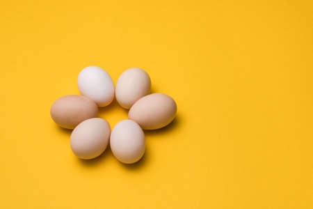 natural ecological eggs in shape of flower on yellow background with copy space. happy easterの写真素材