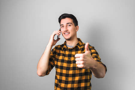 university enrollment. handsome young man or student with smile on face speaking on the phone and...