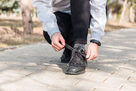 healthy lifestyle. close up view runner tying her laces and getting ready to run