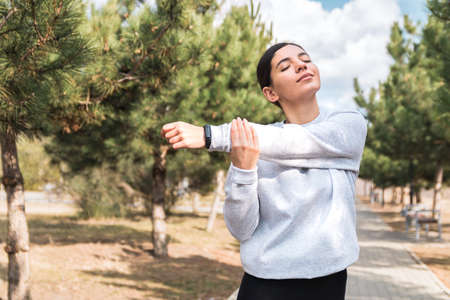 morning stretches. cheerful young woman stretching in park before a run. healthy lifestyle and...