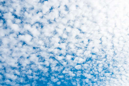 spring blue sky with fluffy clouds moved by the windの写真素材