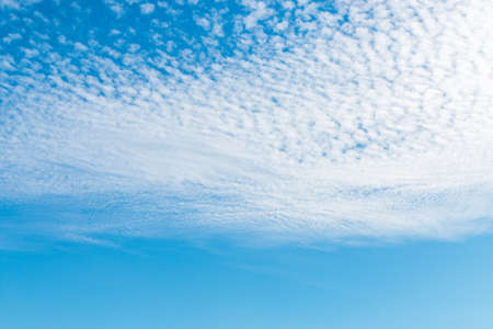 spring blue sky with fluffy clouds moved by the wind.の写真素材