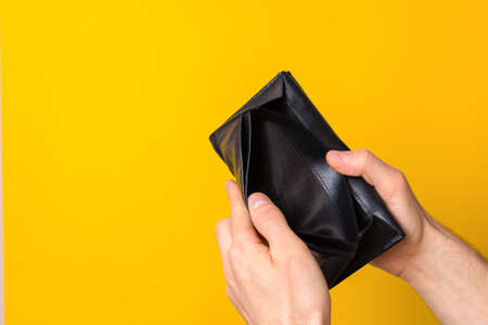 unemployment crisis because of coronavirus pandemic. close up man hands holding empty wallet sign of...