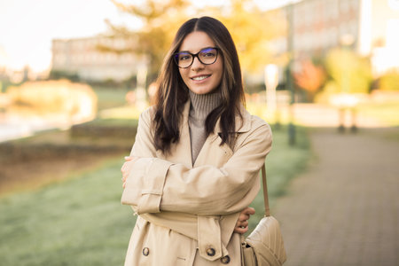 Independent young woman 20-30s wearing glasses with hands crossed in the streetの写真素材