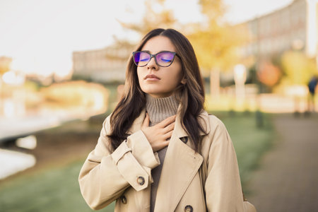 Spring is not always refreshing. A young woman struggles to breathe on a busy street, overwhelmed by seasonal allergies or urban pollutionの写真素材