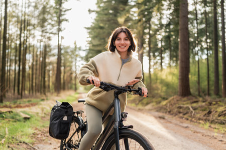 Fresh air, warm light and wild freedom, a modern traveler is cycling into her dream holiday getawayの写真素材