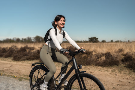 Adventurous traveler pedals on path by the sea, where well-being, sport, and warm-weather cycling align in one serene journeyの写真素材