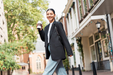 Easy strut big energy as multiracial woman strolls through a sunlit neighborhood radiating self assurance and clarityの写真素材