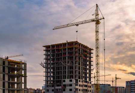 Building crane and building under construction. Construction site. Construction cranes and high rise...