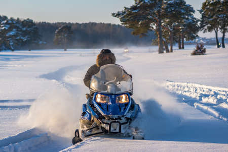 Man on snowmobile. Recreation concept on nature in winter holidays. Winter sports.の写真素材