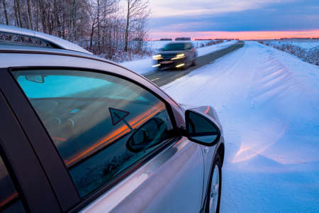 Driving SUV car in winter on forest road with much snow. Oncoming car at a dangerous speedの写真素材