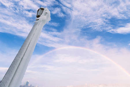 Frozen lamp post with a rainbowの写真素材