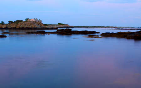 Sunset on a rocky shoreの写真素材