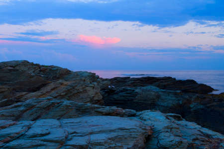 Sunset on a rocky shoreの写真素材
