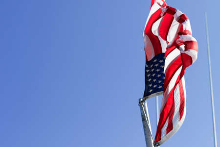 Weathered American flag on a flag pole.の写真素材