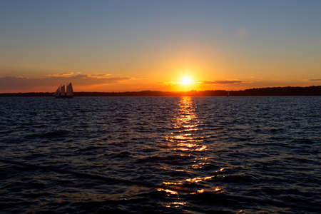 Sail boat at sunset on the ocean.