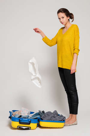 Beautiful sexy girl with a yellow suitcase loves to travelの写真素材