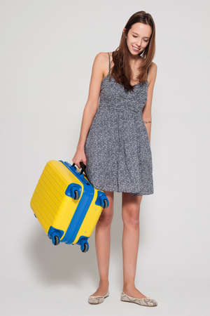 Girl with a yellow suitcaseの写真素材