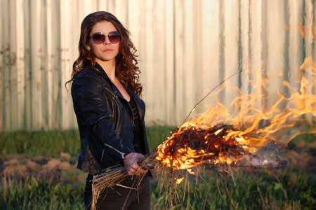 The bad woman in sunglasses and a black jacket holding a torchの写真素材