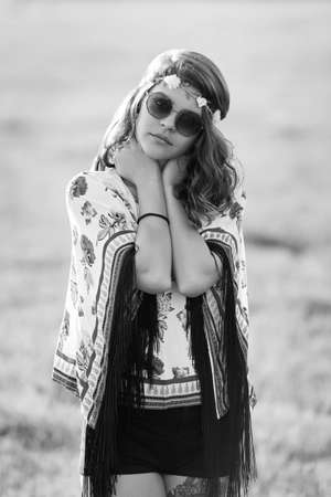 Black and white portrait of a beautiful girl hippie standing and looking at the cameraの写真素材