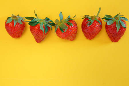 Tasty fresh strawberries on a yellow backgroundの写真素材