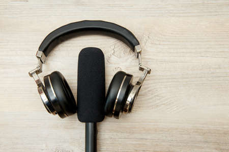 Wireless headphones and microphone on a wooden table.の写真素材