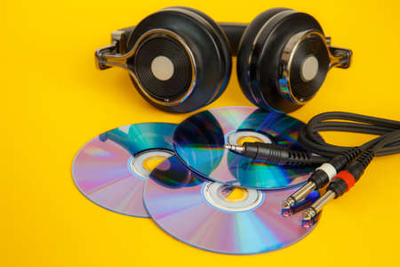 Headphones and music discs on a yellow background. Musical concept.の写真素材