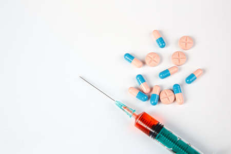 A pile of medical pills of different colors and syringe. Syringe and pills. Coronovirus