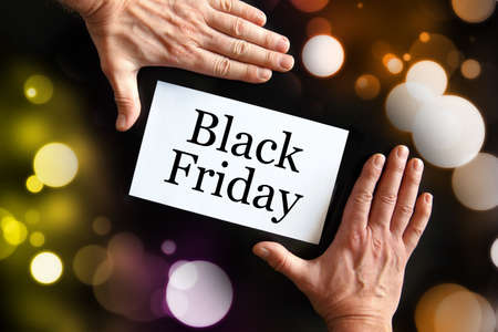 Man's hands holding a card with the inscription Black Fridayの写真素材