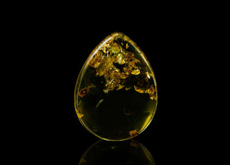 Sunny amber on a black background in the form of a drop.