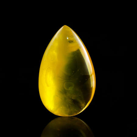 A unique piece of solar amber on a black background.の写真素材