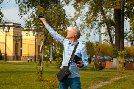 A man launches a drone from his hand. A man holds a drone on his outstretched arm