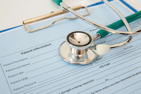 Stethoscope and patient appointment form on a white table.