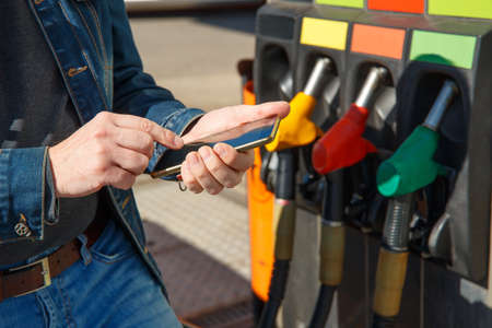 Refueling a car and paying using the application on a smartphone.の写真素材