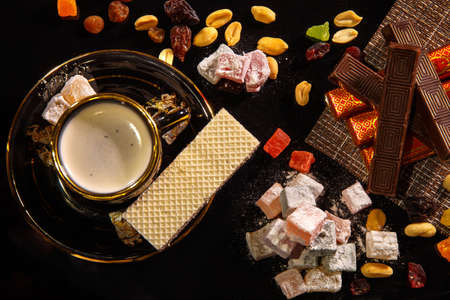Natyutmort oriental sweets and a cup of hot coffee on a black background.の写真素材
