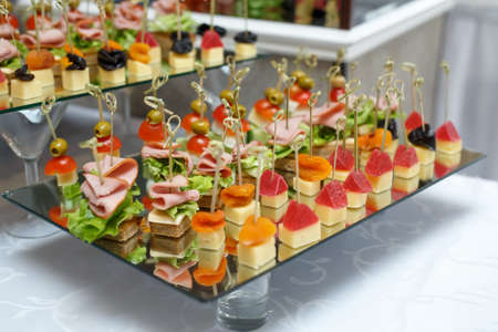 Delicious canapes with ham, cheese and fruit. Snacks