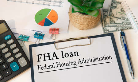 Office desk with documents, concept image for blog headline or header image. Federal Housing Administration FHA loan inscription on paper.の写真素材
