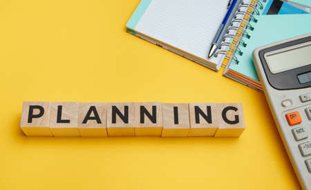 PLANNING word from wooden blocks on a yellow backgroundの写真素材