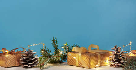 Christmas or new year composition, wooden blue background and golden christmas decorations and giftsの写真素材