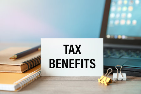TAX BENEFITS - an inscription on a card near office supplies and computerの写真素材