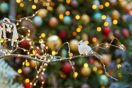 Bird on a branch - Christmas or New Year composition, decoration close-up on a background of lightsの写真素材