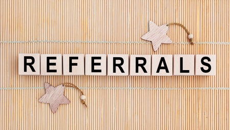 Wooden cubes with the abbreviation REFERRALS on wooden backgroundの写真素材