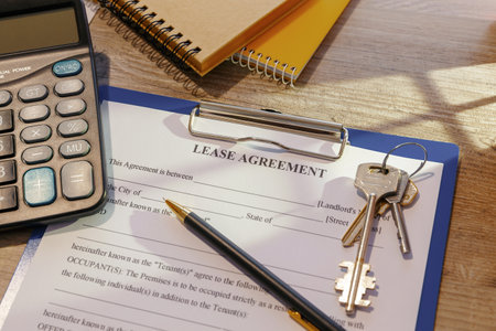 Blank real estate lease agreement, keys and calculator on office desk