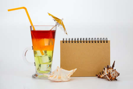 Bright summer cocktail in a glass and notebook. Travel concept.の写真素材