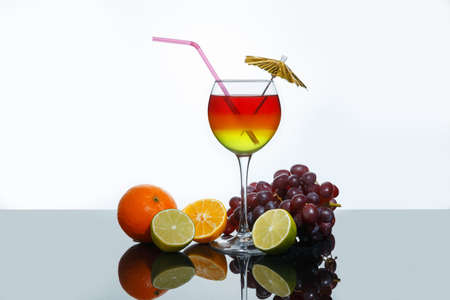 Bright summer cocktail in a glass and fruits on a white backgroundの写真素材