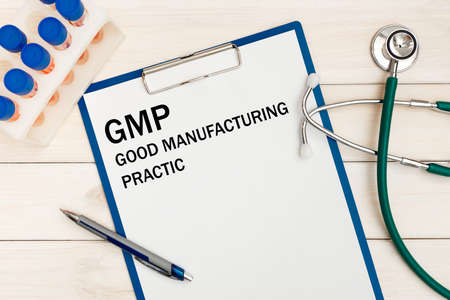 Paper with GMP - Good Manufacturing Practice on the office desk, stethoscope and penの写真素材