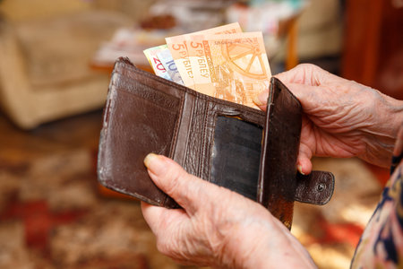 A very old woman takes out of her wallet the banknotes of the Republic of Belarus. Hands close-up.