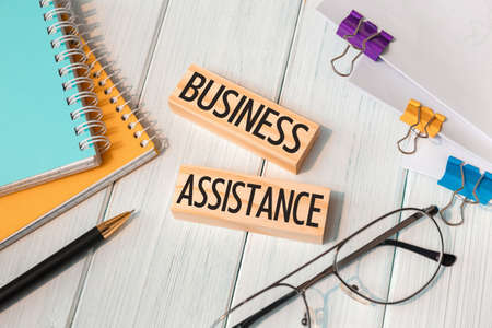 Business Assistance - words written on wooden blocks near office suppliesの写真素材